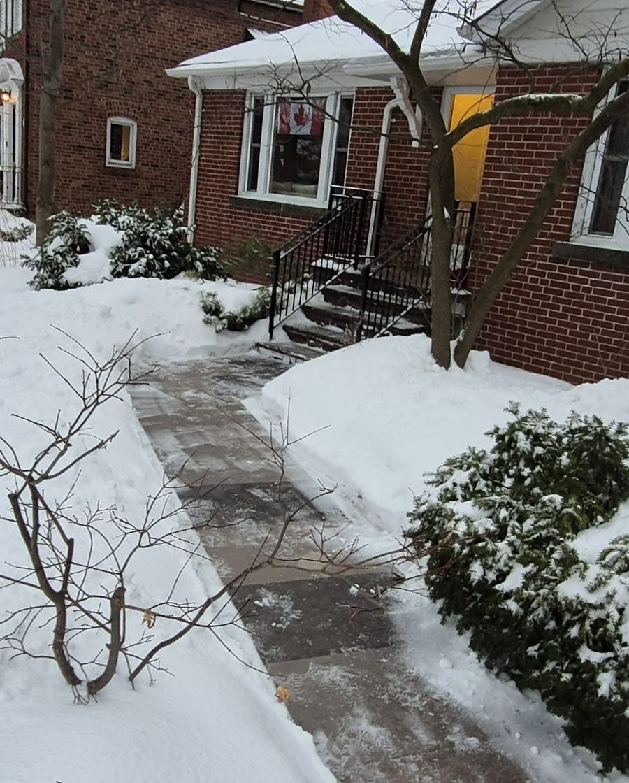 Front walkway to a Toronto brick house shovelled clear between snowbanks